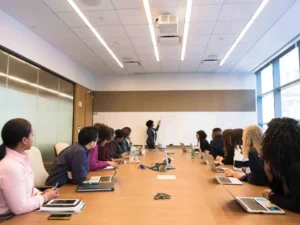 Business team attending a conference room meeting with presentation on whiteboard